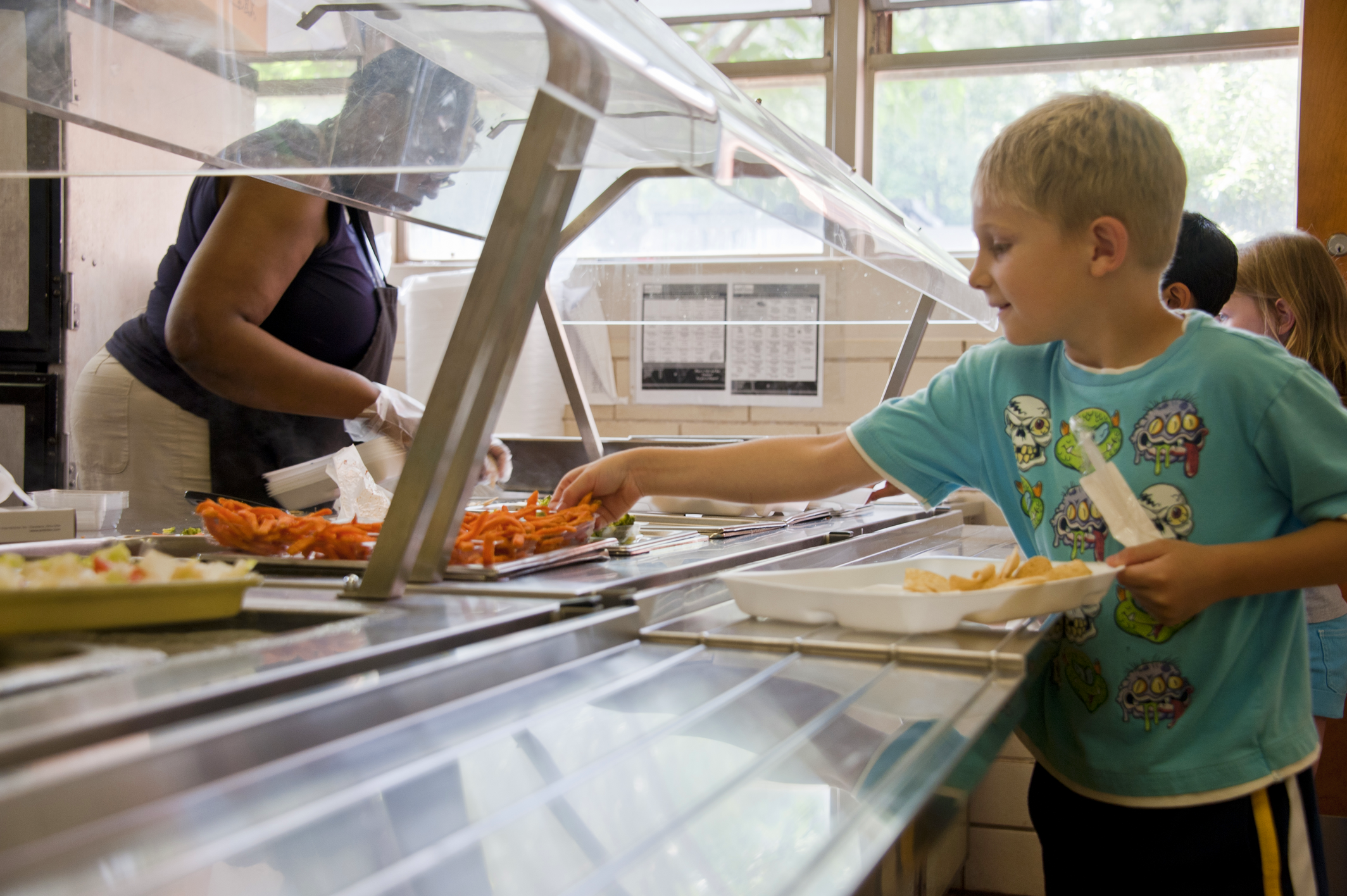 Young boy selecting some of the sweet potato fries, which he’d place atop his disposable foam food plate. Courtesy of the Public Health Image Library, Centers for Disease Control and Prevention.